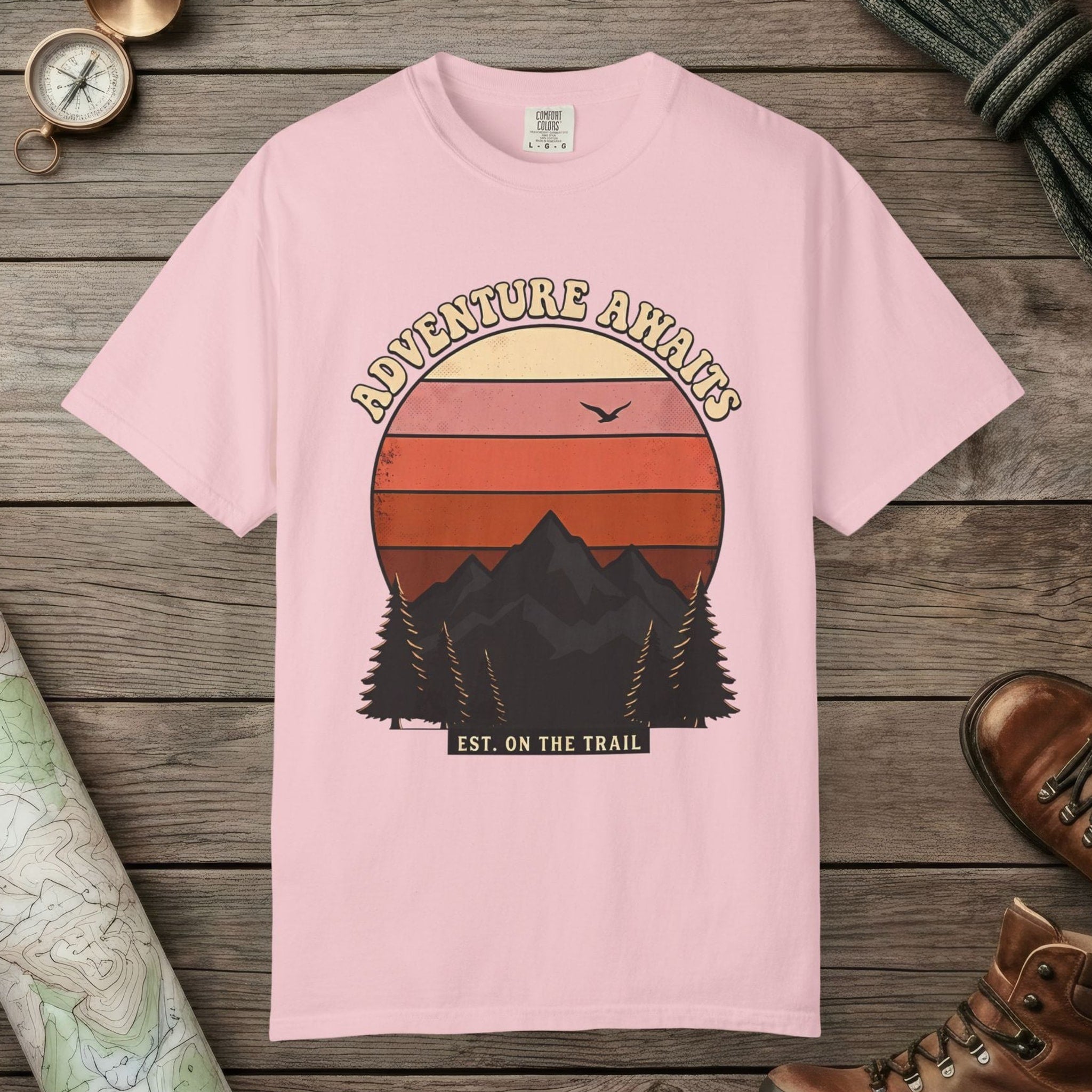 Blossom color unisex graphic t-shirt with "Adventure Awaits Retro Sunset" design