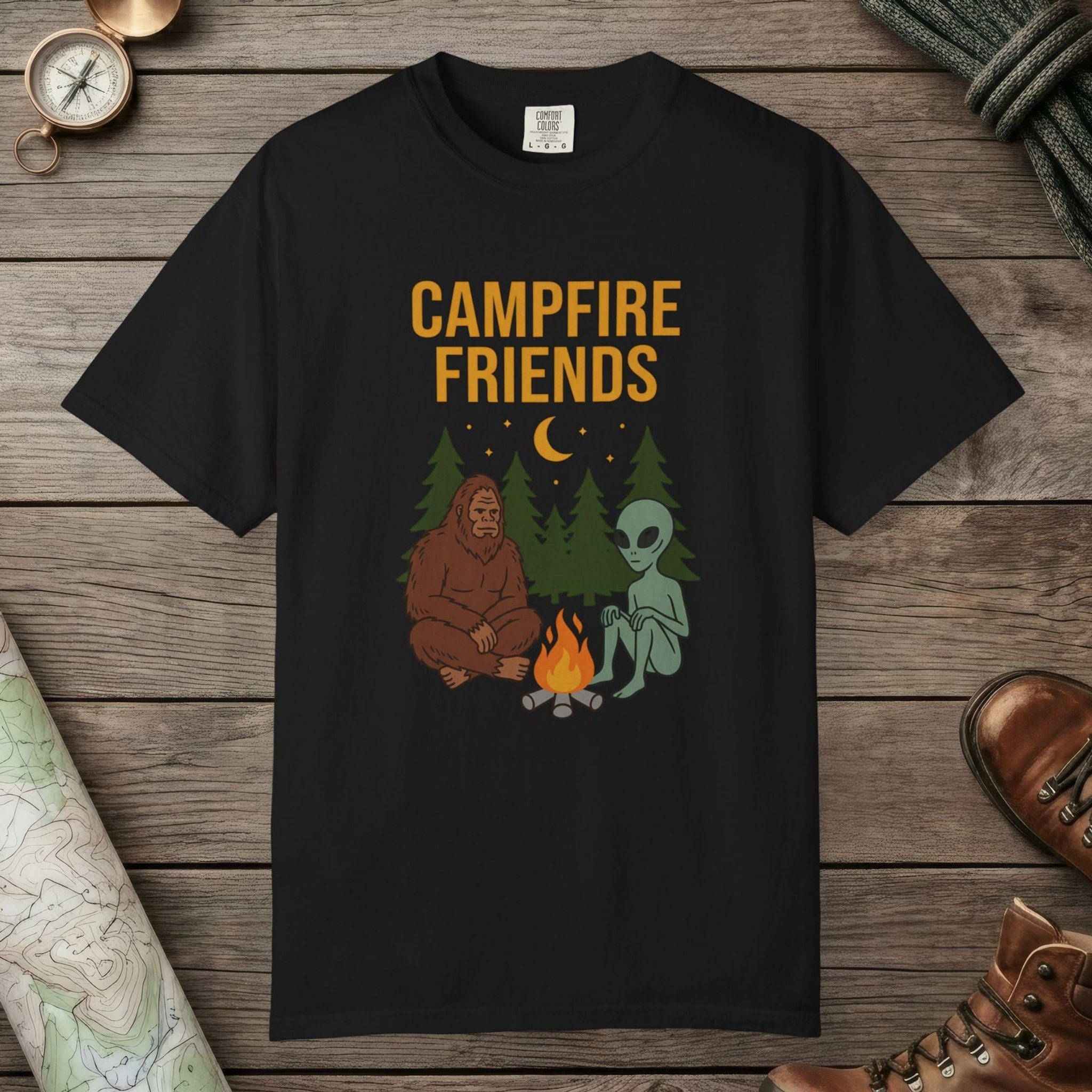 Black color unisex graphic t-shirt with "Bigfoot And Alien Campfire" design