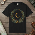 Black color unisex graphic t-shirt with "Moon & Wildflower Wreath" design