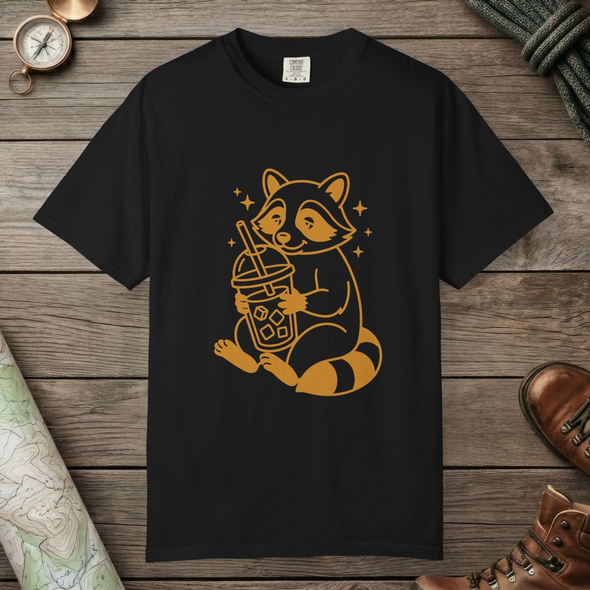 Black color unisex graphic t-shirt with "Raccoon with Iced Drink" design
